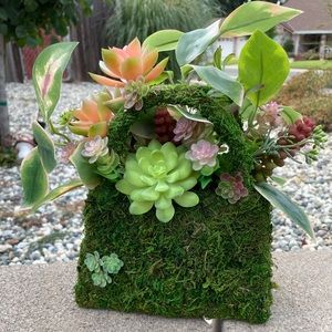 Cute mossy purse. Filled with faux greenery and succulents. 10” tall